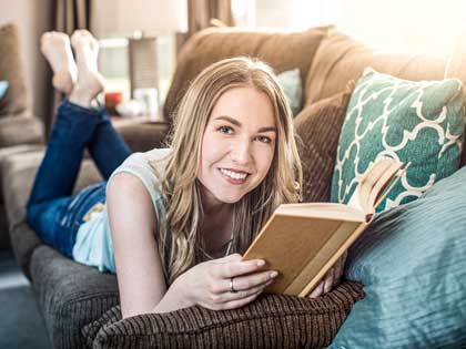 Büchershop Frau liest Buch auf Sofa